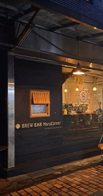 丸角自轉生活咖啡 委託行轉角店面街景,夜裡亮著暖燈的老街